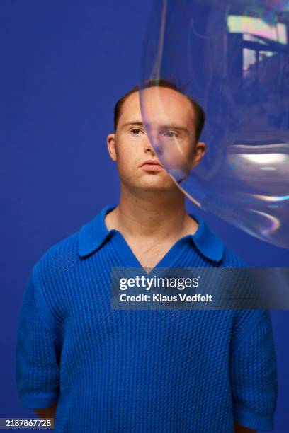 man with down syndrome standing near bubble - blue stock pictures, royalty-free photos & images