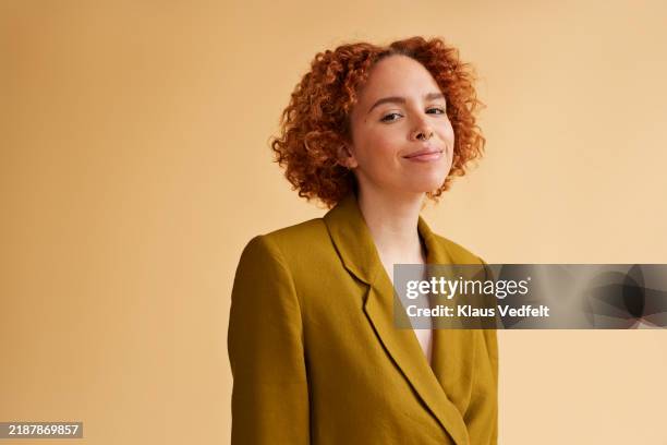 smiling young redhead non-binary person in green blazer - portrait stock pictures, royalty-free photos & images