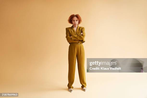 confident redhead non-binary person in green blazer with arms crossed - trousers stock pictures, royalty-free photos & images