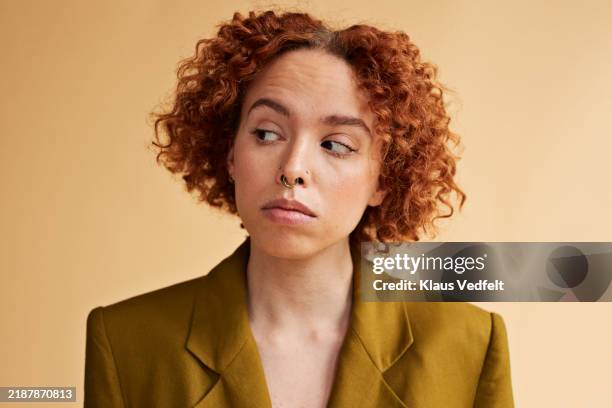 confident young redhead non-binary person looking sideways - suspicion stock pictures, royalty-free photos & images