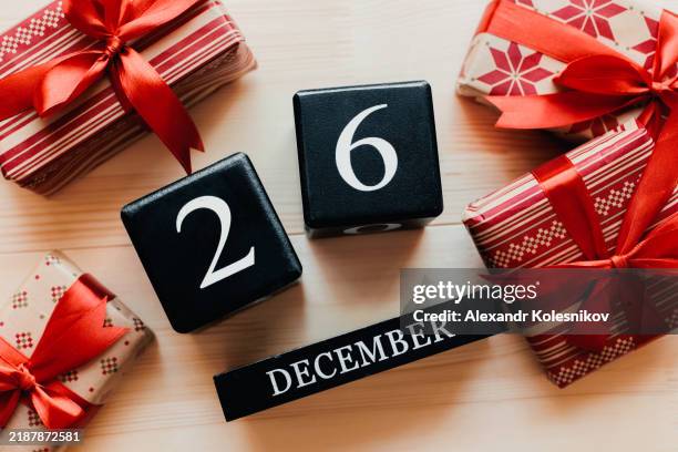 boxing day concept. various presents gift boxes with red ribbon. block calendar with date 26 december - saint étienne photos et images de collection