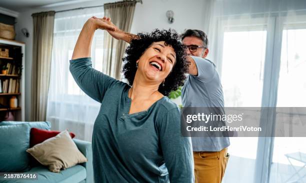 mature couple dancing at home - lifestyle imagens e fotografias de stock