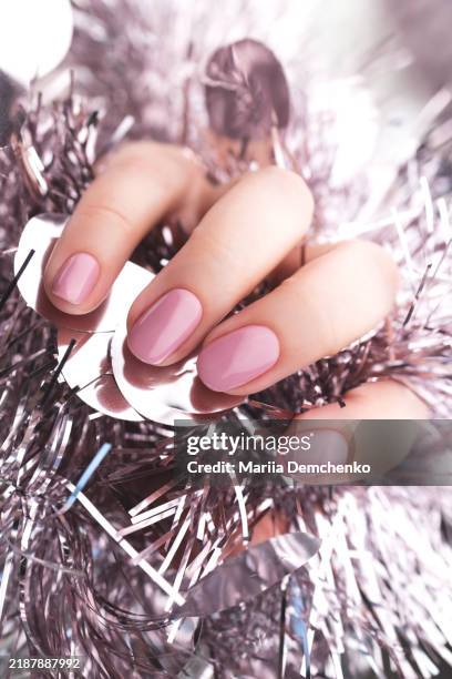 hand with beautiful manicure - pink gel nails with christmas tinsel - pink nail polish stock pictures, royalty-free photos & images