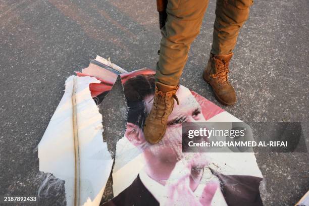 An anti-government fighter steps on a torn up portrait of Syria's President Bashar al-Assad in Hama, a day after rebels captured the central-west...
