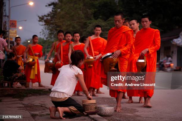 escena callejera de madrugada con monjes en luang prabang, laos - limosna fotografías e imágenes de stock