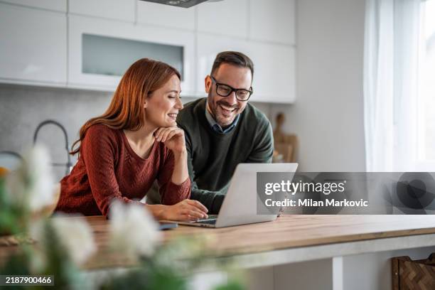 photo of a young couple working from home together, striking the perfect balance between work and support - home stockfoto's en -beelden