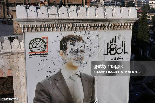 This aerial picture shows a bullet-riddled portrait of Syrian President Bashar al-Assad adorning Hama's municipality building after it was defaced...
