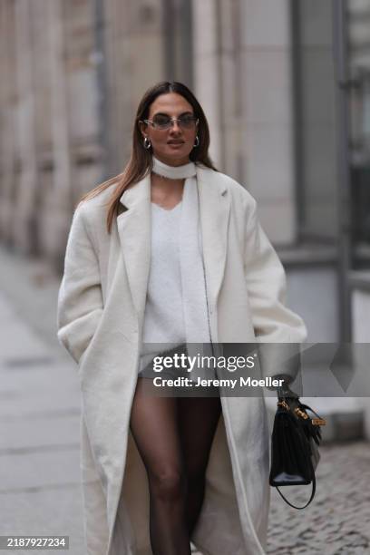Anna Winter is seen wearing sunglasses with rimless oval grey lenses, a silver metal nose bridge, and transparent temples with silver logo detail...