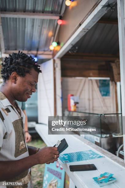 man making a purchase at a market food stall with cash - booth stock pictures, royalty-free photos & images