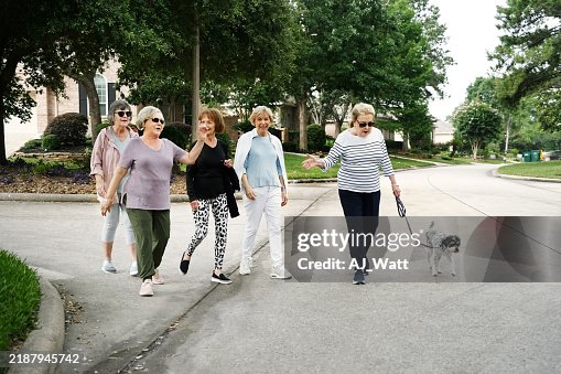 Senior women walking with dog on neighborhood road Senior women walking with dog on neighborhood road