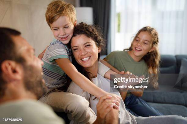 famiglia allegra che si diverte mentre parla a casa. - genitori foto e immagini stock