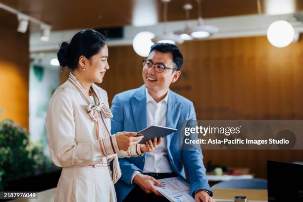 asian business partners working on a digital tablet and laptop computer in the office. - pessoa de cor imagens e fotografias de stock