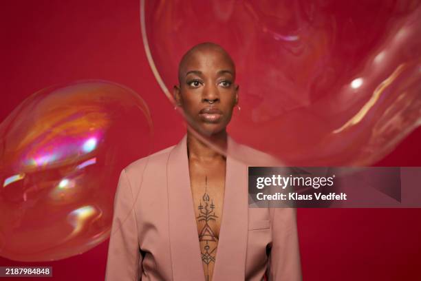 non-binary person with phobia staring at bubbles - neurodiversidad fotografías e imágenes de stock