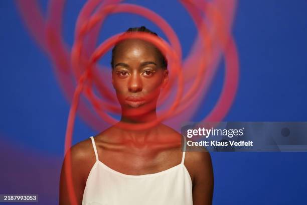 confident young woman looking through spiral red wire - pattern stock pictures, royalty-free photos & images