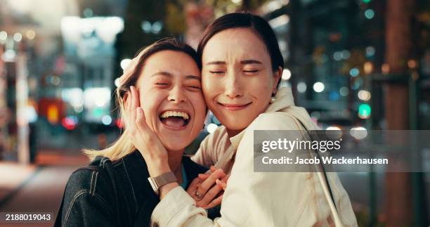 Happy, asian women and night with hug for love, care or bonding together in an urban town or city. Japan, female people or friends with smile in late evening for travel or fun moment in Tokyo street