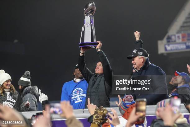 Head Coach Spencer Danielson of the Boise State Broncos hoists the Mountain West Championship trophy after defeating the UNLV Rebels at Albertsons...