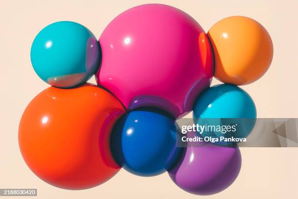 shiny colorful spheres are intertwined creating vibrant abstract composition on light beige background - colorful balloons stock pictures, royalty-free photos & images