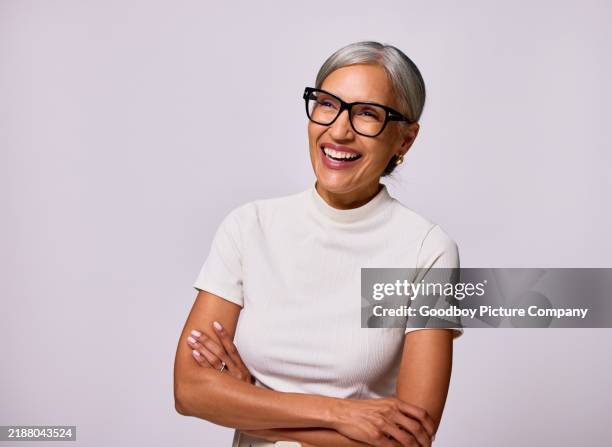 portrait of mature woman wearing glasses, smiling and laughing with arms folded - da cintura para cima imagens e fotografias de stock