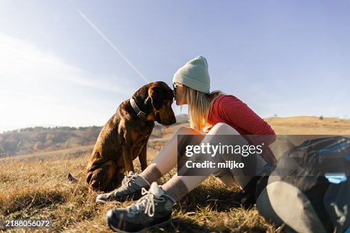 Woman with her dog taking a break from hiking Woman with her dog taking a break from hiking
