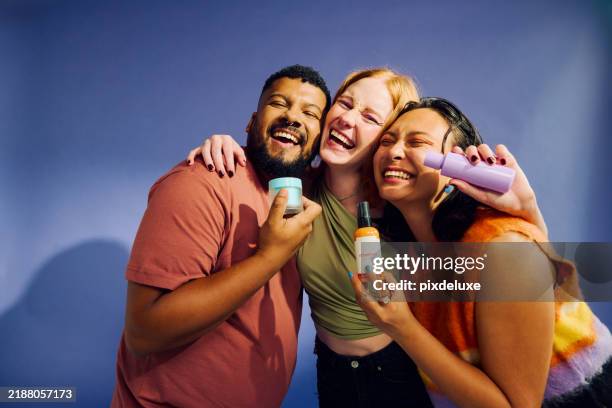 happy gen z friends showing beauty products, enjoying skincare and wellness routine - male personal grooming stock pictures, royalty-free photos & images