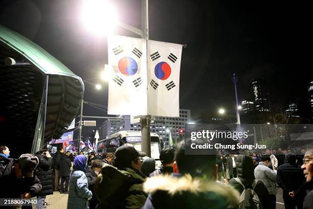 People gather in front of the National Assembly on December 04, 2024 in Seoul, South Korea. South Korean lawmakers voted to lift the declaration of...