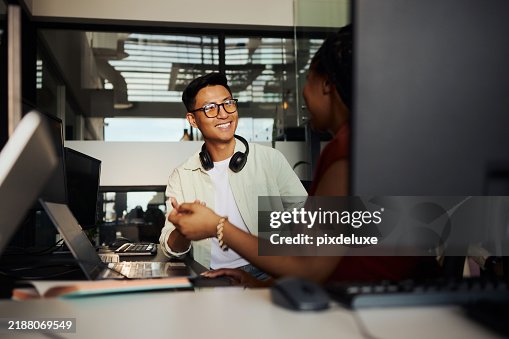 Programmers working together on a computer in office discussing a project Programmers working together on a computer in office discussing a project