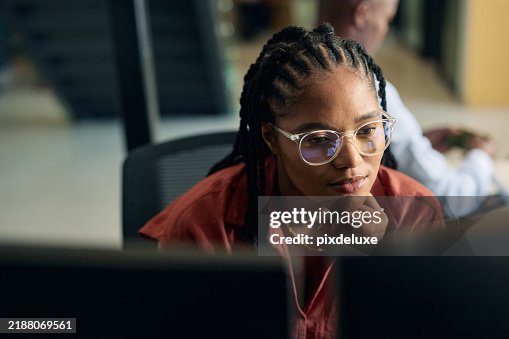 Young woman programmer focused on her work, coding on dual monitors in a modern office environment Young woman programmer focused on her work, coding on dual monitors in a modern office environment
