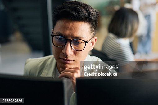 Young asian man working as software developer, coding on computer in modern office Young asian man working as software developer, coding on computer in modern office