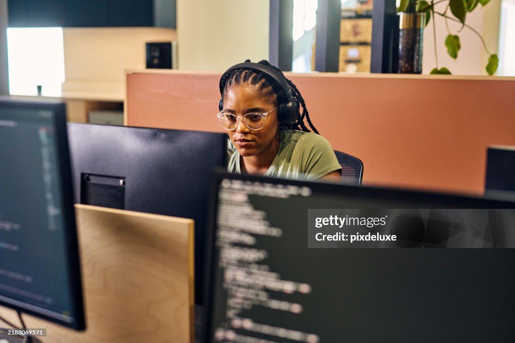 Young Woman Programmer Focused On Her Work Coding On Dual Monitors In A ...