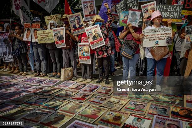 Protesters stand next to portraits of victims of former President Duterte's drug war and other slain activists, as they take part in a demonstration...