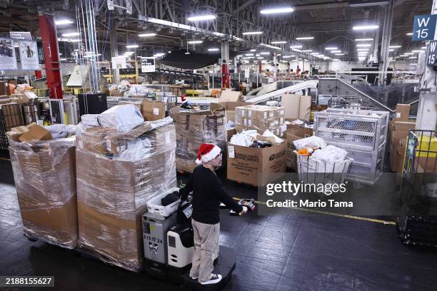 Postal Service employee transports parcels for distribution during the start of the holiday mail rush, following Black Friday and Cyber Monday,...