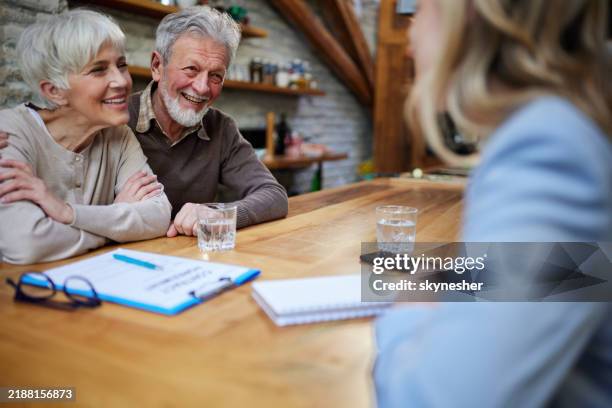 happy senior couple talking to insurance agent at home. - inheritance stock pictures, royalty-free photos & images