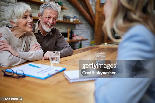 Happy senior couple talking to insurance agent at home. Happy senior couple talking to insurance agent at home.
