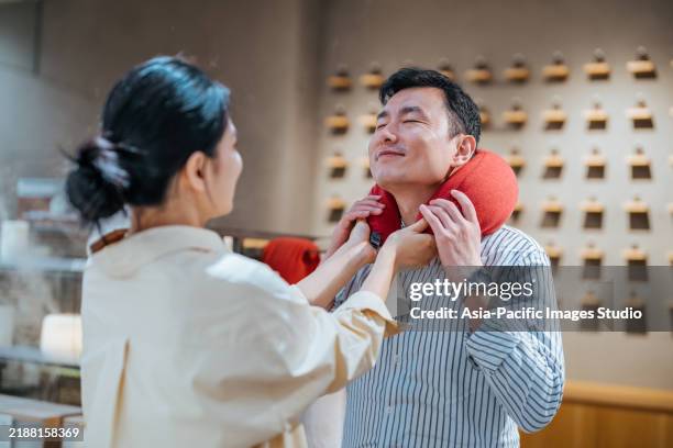 asian couple choosing neck pillow. - neck pillow stock pictures, royalty-free photos & images