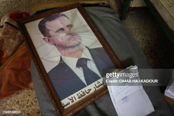 Portrait of Syrian President Bashar al-Assad is pictured with its frame broken, in a Syrian regime's Political Security Branch facility on the...