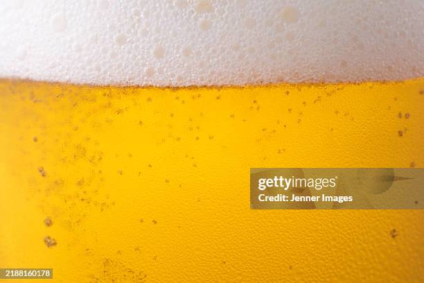 close up foamy beer head - bière photos et images de collection