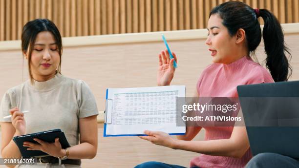 Asian Female Professional Team Presentation With Data Analysis In A Casual Modern Workspace High-Res Stock Photo