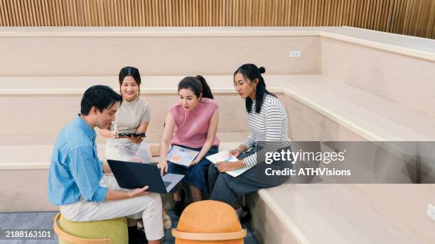 junge berufstätige brainstormen ein kreatives projekt in einer ungezwungenen büroumgebung - mitarbeiterbindung stock-fotos und bilder