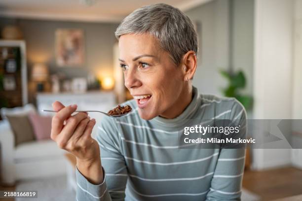 woman enjoying granola - granola stockfoto's en -beelden
