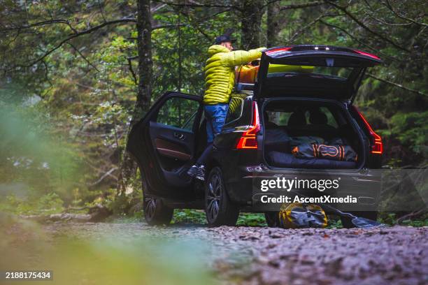 kayaker loads suv with sports equipment - car roof rack stock pictures, royalty-free photos & images