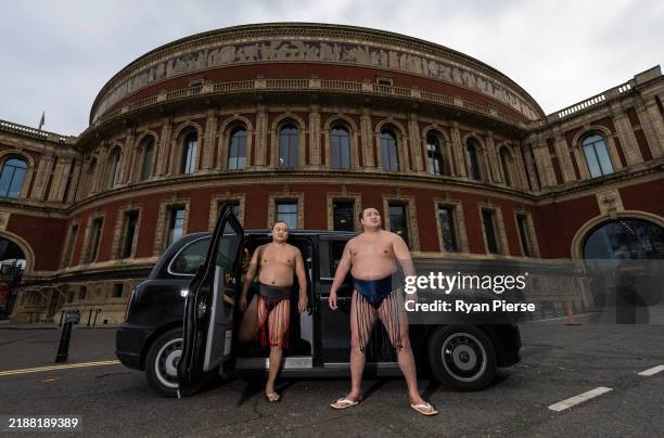 Sumo Wrestlers Kitanowaka Daisuke and Fukutsuumi Akira of Japan pose with a London Black Cab following The Grand Sumo Tournament press conference at...