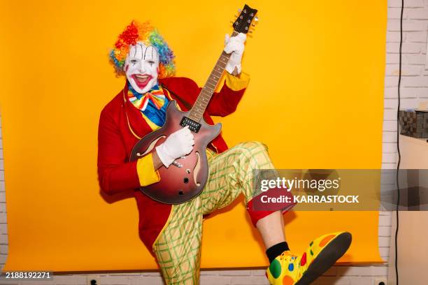 rock 'n' roll clown plays electric guitar - músico de rock imagens e fotografias de stock