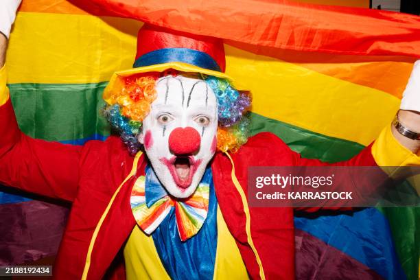 cheerful clown holding a rainbow flag, vibrant expression. - clown makeup stock pictures, royalty-free photos & images