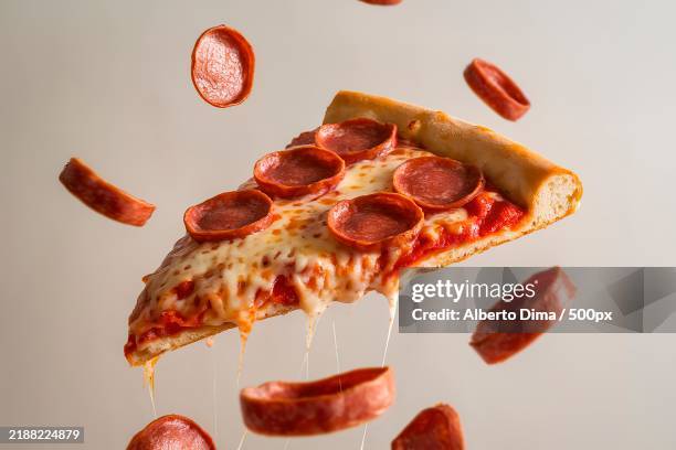 a slice of pizza with pepperoni toppings,suspended in mid-air - pizza imagens e fotografias de stock