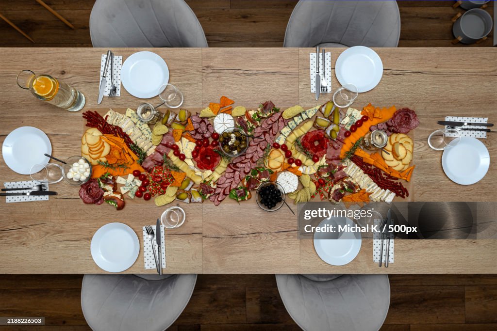 Various cheeses and cold cuts spread out on the table on baking paper,Evening party at home