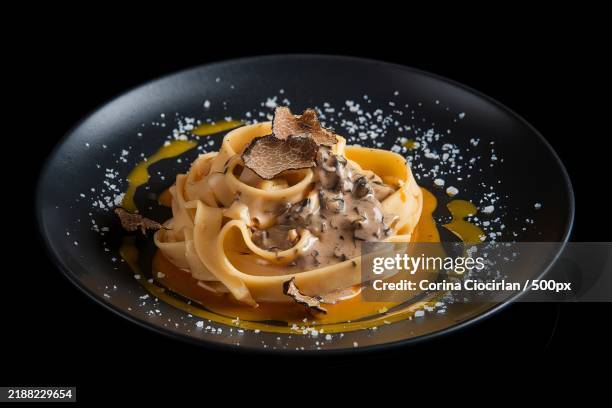 a plate of home-made egg pasta the pasta is served with a truffle sauce and drizzled with truffle-infused oil - tagliatelle fotografías e imágenes de stock