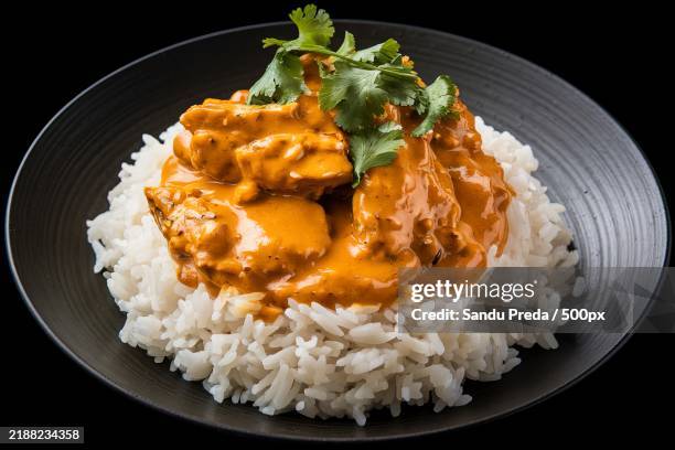 a plate of steamed white rice with a curry chicken dish on top - white rice stock pictures, royalty-free photos & images