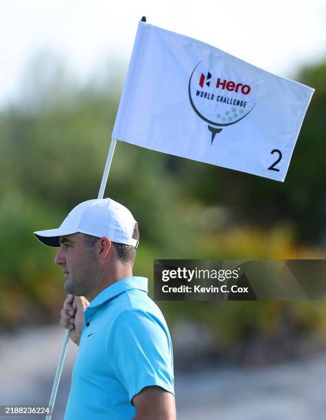 Scottie Scheffler of the United States removes the flagstick on the second green during a pro-am prior to the Hero World Challenge 2024 at Albany...