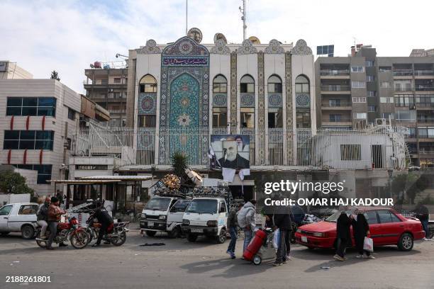 People load items looted from the Iranian embassy onto trucks in the Syrian capital Damascus on December 8, 2024. Islamist-led rebels declared that...