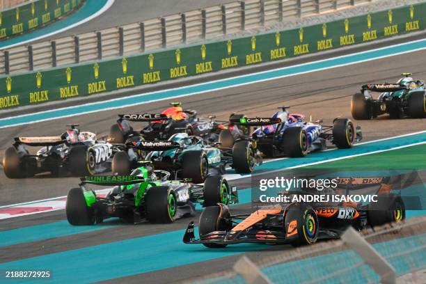 McLaren's Australian driver Oscar Piastri drives after a collision with Red Bull Racing's Dutch driver Max Verstappen during the start of the Abu...